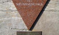 Mindeplade i Berlin for nazismens homoseksuelle ofre. Inskripitionsteksten er: Totgeschlagen – Totgeschwiegen (slået ihjel – tiet ihjel). I dag bruges den lyserøde trekant som et symbol på homoseksuelles rettigheder. ©Manfred Brueckls