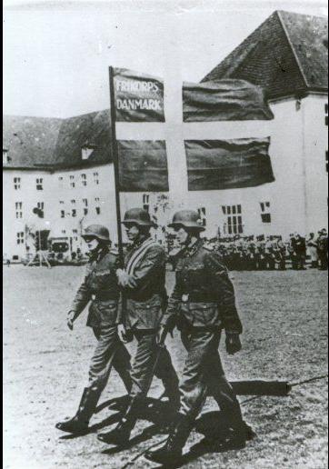 Frikorps Danmarks fane bæres frem i forbindelse med de frivilliges aflæggelse af SS-eden på kasernen Hamburg-Langenhorn. De frivillige forpligtede sig til ubetinget lydighed mod Hitler som den tyske værnemagts øverstbefalende ©Frihedsmuseet