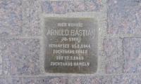 Stolperstein eller snublesten. Mindesmærke for ofre for nazisterne. Stolpersteine placeres der, hvor offeret boede og fortæller hvad der skete med vedkommende. Denne sten er for den homoseksuelle Arnold Bastian